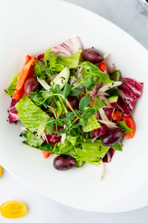 salad of greens, lettuce leaves, cucumbers, pink onions, side viewの写真素材