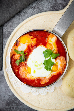 borscht in a frying pan with fresh flatbreads and cherry tomatoes top viewの写真素材