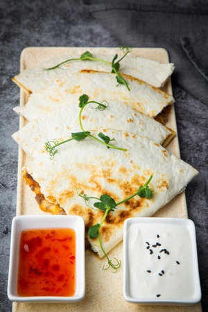 chicken quesadilla with herbs sauce and sour cream side viewの写真素材