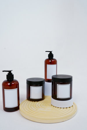 Body care. a set of bottles with dispensers and jars of body cream on a geometric stand and on a light gray background. Advertising conceptの写真素材
