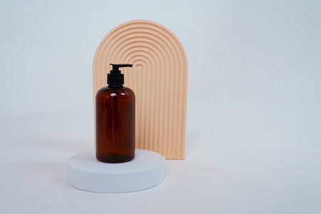 Composition with geometric shapes.body care. bottle with a dispenser, on a light gray background. Advertising conceptの写真素材