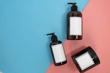 Body care. set of bottles with dispensers and jars of body cream on a blue and pink background. Advertising conceptの写真素材