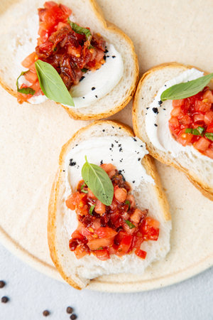 bruschetta with tomatoes and labneh cheese on a light background top viewの写真素材
