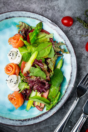 salad of leaves of different types of lettuce and fish rolls, top viewの写真素材