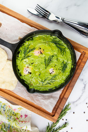 broccoli cream soup with herbs, cheese and tortillas in a frying pan, top viewの写真素材