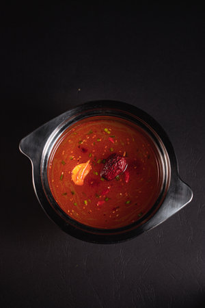 soup broth in an iron plate on a dark background side viewの写真素材