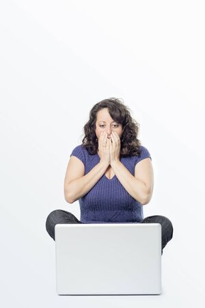 Picture of a young woman with surprise expression in front of a laptop