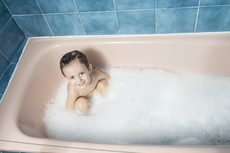 Color photography of a smiling child playing in the bubble bathの写真素材