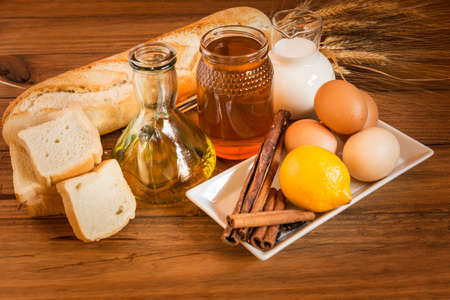 Still life with the ingredients for making french toast placed on a wooden table