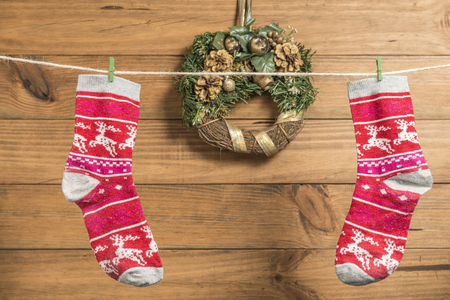 Christmas background with two red socks placed on a rope with clothespins with wooden boards in the background.の写真素材