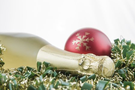 Holiday concept. Bottle of champagne and christmas decorations on garlands with white background.の写真素材