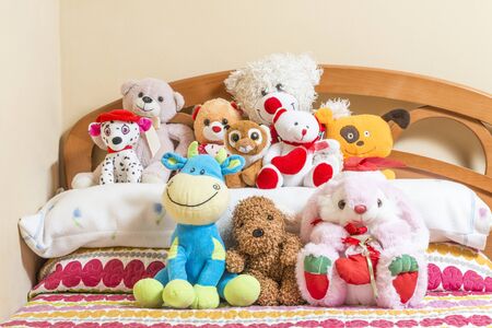 A lot of cuddly toys on top of a bed.の写真素材