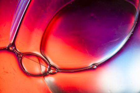 Abstract shapes created by several soap bubbles attached on a colorful background.
