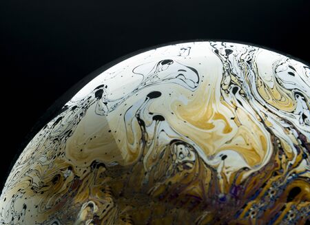 Colors and shapes created the surface of a soap bubble on black background.