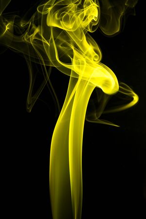 Abstract shape of yellow smoke on black background.の写真素材