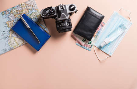 Conceptual still life with various objects related to travel and mask, on pink background. Travel concept during the covid19 coronavirus pandemic.の写真素材