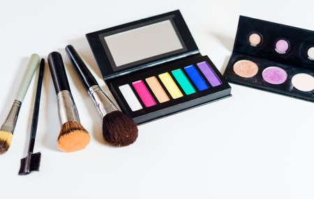 Still life with multi color makeup brushes and cases on white background.