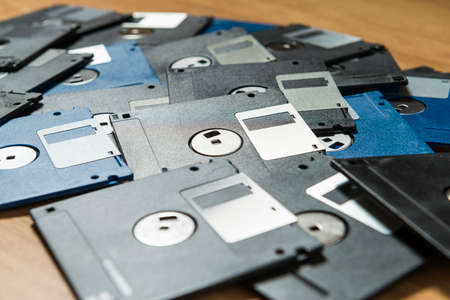Some old computer floppy disks on a wooden board. Concept of technological waste and its recycling.の写真素材