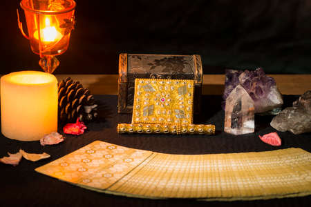 Tarot cards and other objects on a black card table for a fortune telling session. Concept of a...