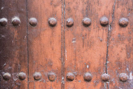 Textured background of a brown wooden door with nails. Copy space.の写真素材