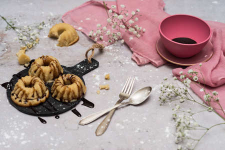 Still life with cakes decorated with chocolate and icing sugar on a white background.の写真素材