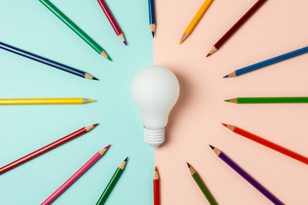 Light bulb and colored pencil on blue and pink backgroundの写真素材