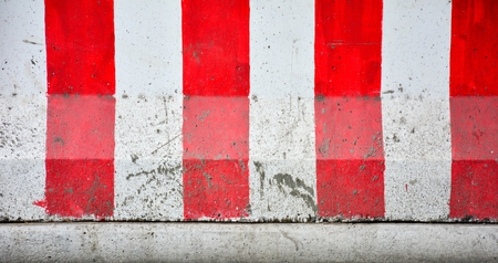 Red and white concrete barriers blocking the road - closeup