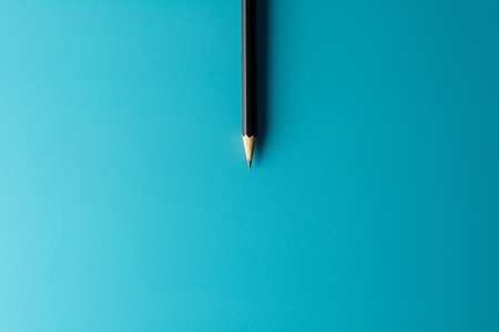 Black pencil on blue paper background. - Business concept.の写真素材