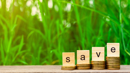 save word stack of coins and a pile of golden coins on wooden table. -  Concept of saving.の写真素材