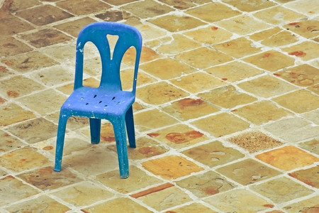 old blue plastic chair on the brick floorの写真素材