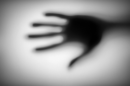 blurred of a hand behind matted glass.の写真素材