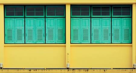 blue window at antique yellow concrete buildingの写真素材