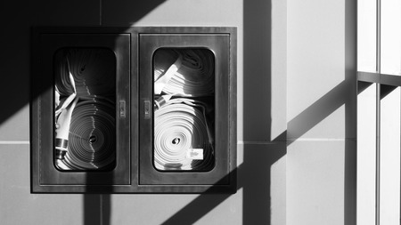 fire hose hanging on the wall - monochrome