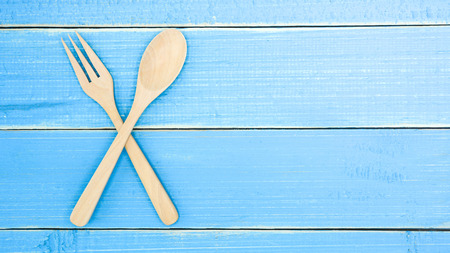 Wooden spoon and fork on old blue wood desk backgroundの写真素材