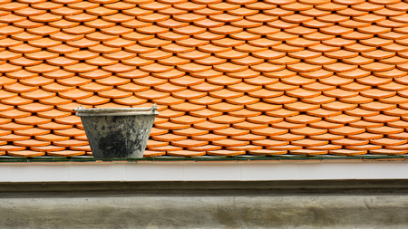 a black construction plastic bucket on the antique temple roofの写真素材