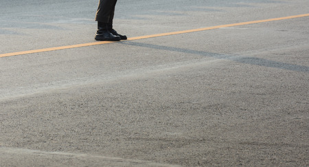 boots of soldier standing on asphalt road in the urbanの写真素材
