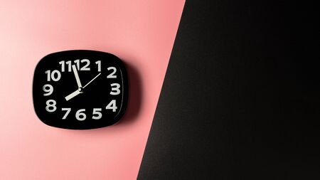 black clock on pink and black background.の写真素材