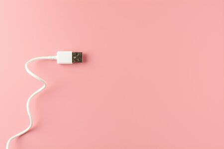 white USB cable on pink background.の写真素材