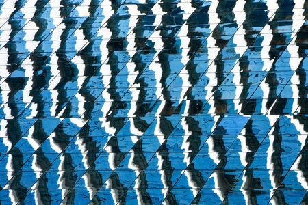 abstract pattern of modern glass windows with reflection from building at the skyscrapers.