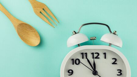 lunch time with alarm clock on blue background.の写真素材