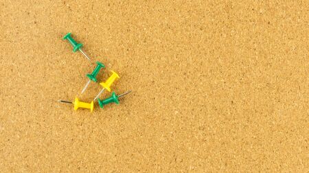 yellow and green push pin on blank cork board.の写真素材