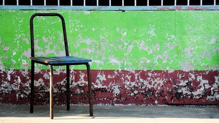 old and damaged steel chair in rural schoolの写真素材