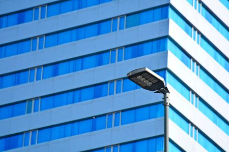 lamp post electricity industry with blue glass window buildingの写真素材