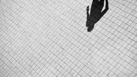 shadow of human on a brick floor - monochromeの写真素材