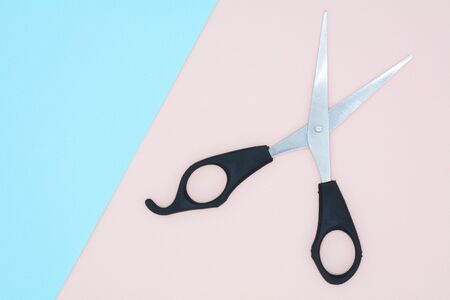 black scissors on blue and pink paper backgroundの写真素材