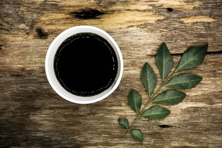 Cup of coffee to go on the wooden table - vintage styleの写真素材