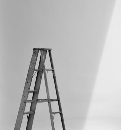 aluminum foldable ladder and the shadow at white cement wallの写真素材