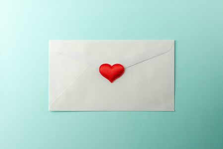 red hearts stamped at white envelope on blue paper background. - Love and care message concept.の写真素材
