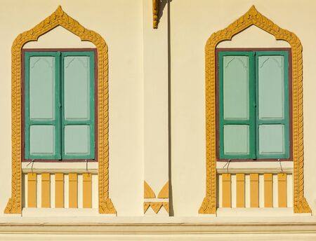 green wood window at asian classic yellow buildingの写真素材