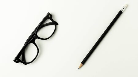 glasses and a pencil on white background for business conceptの写真素材